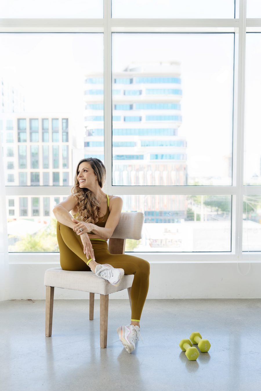 Cici seated by a window overlooking the city