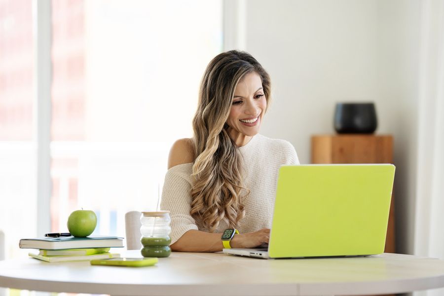 Cici working at a table with a chartreuse laptop