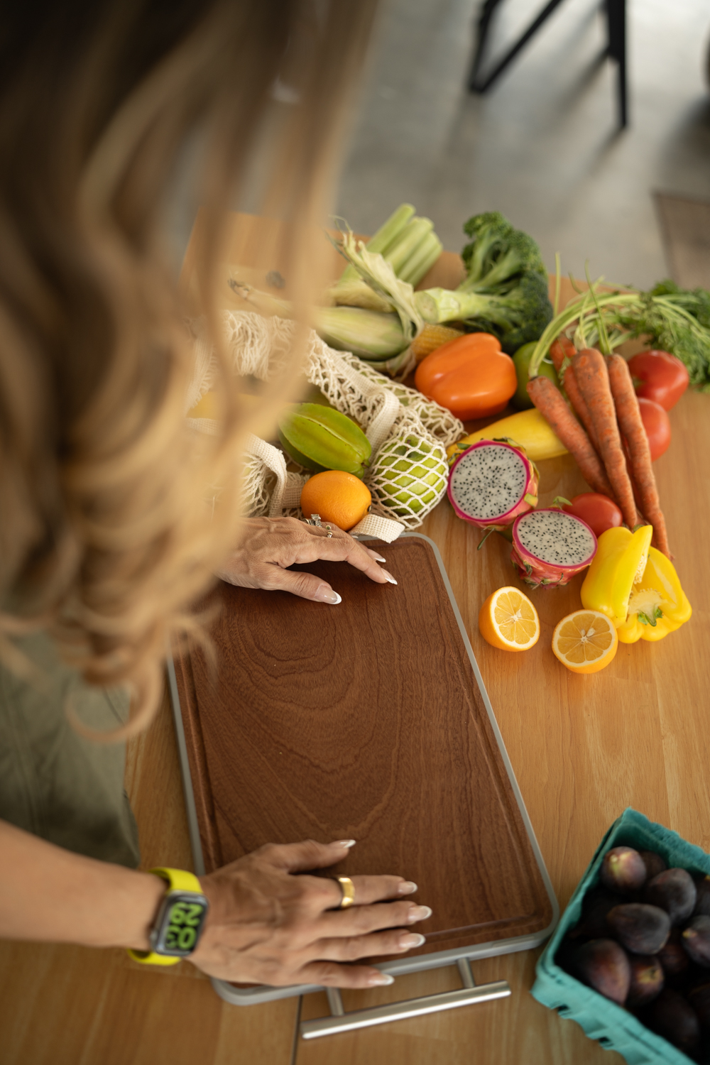 Fresh citrus fruit and green vegetables arranged on a kitchen surface